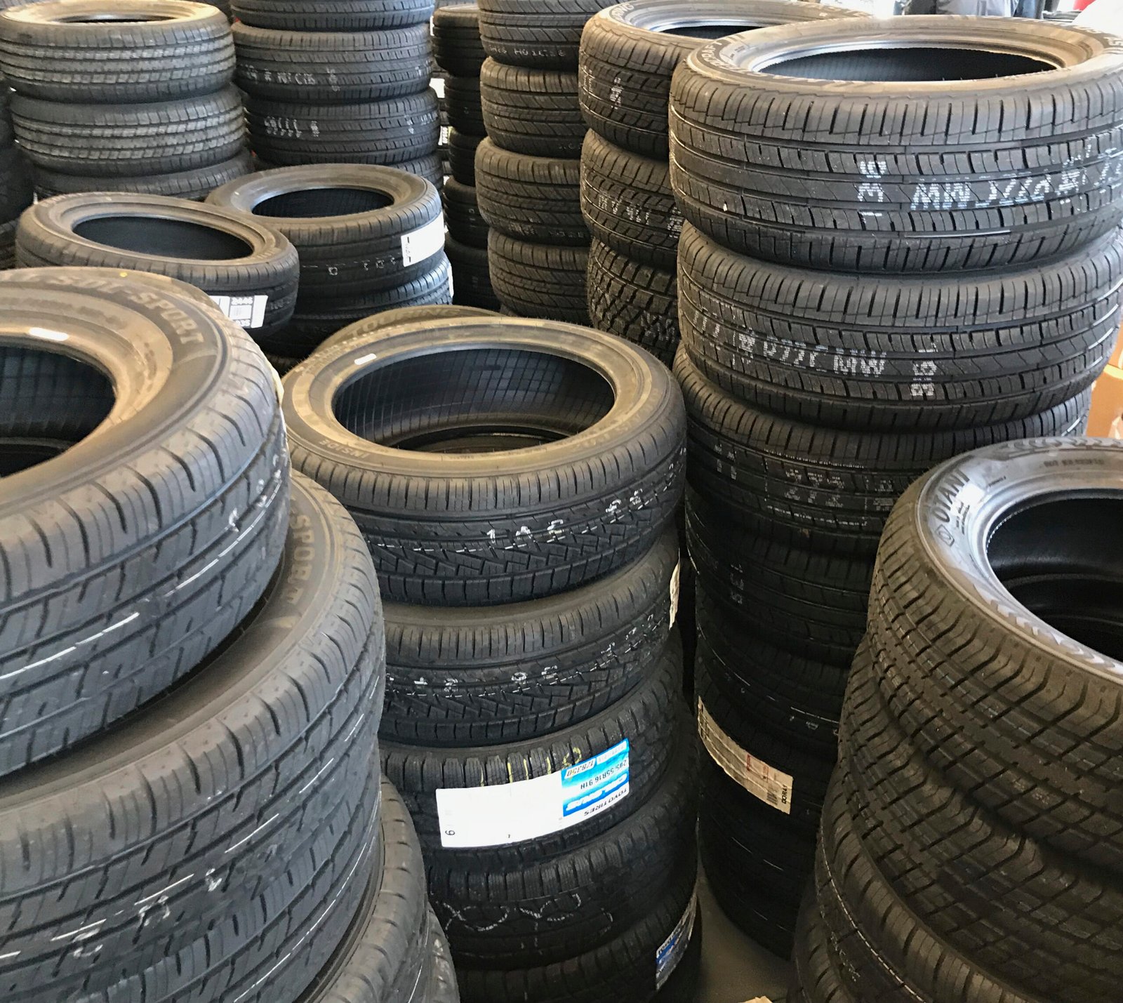 Pneus automotivos pretos empilhados com diversos desenhos de banda de rodagem